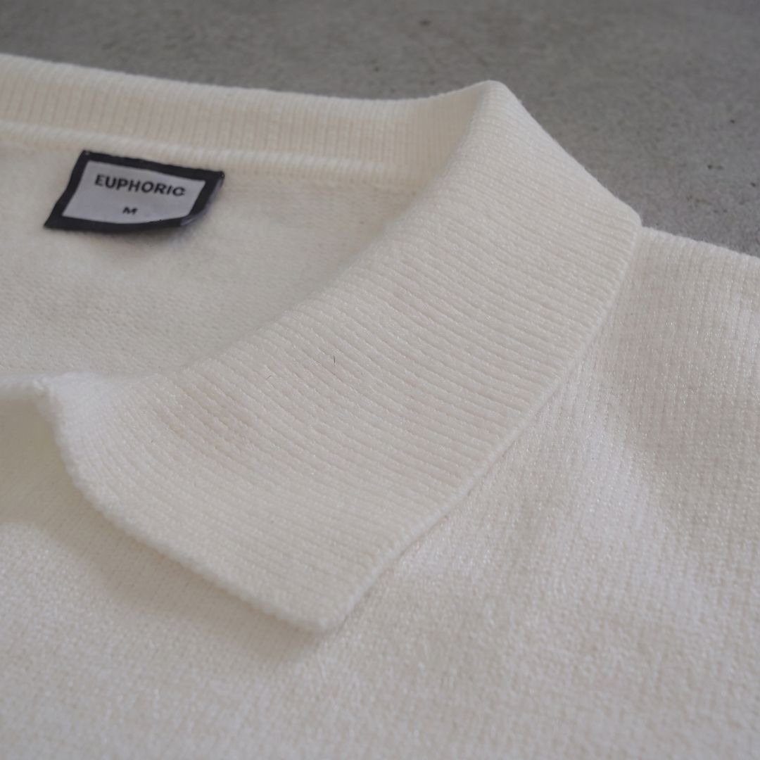 Euphoric pearl white polo shirt collar with brand label tag on concrete background