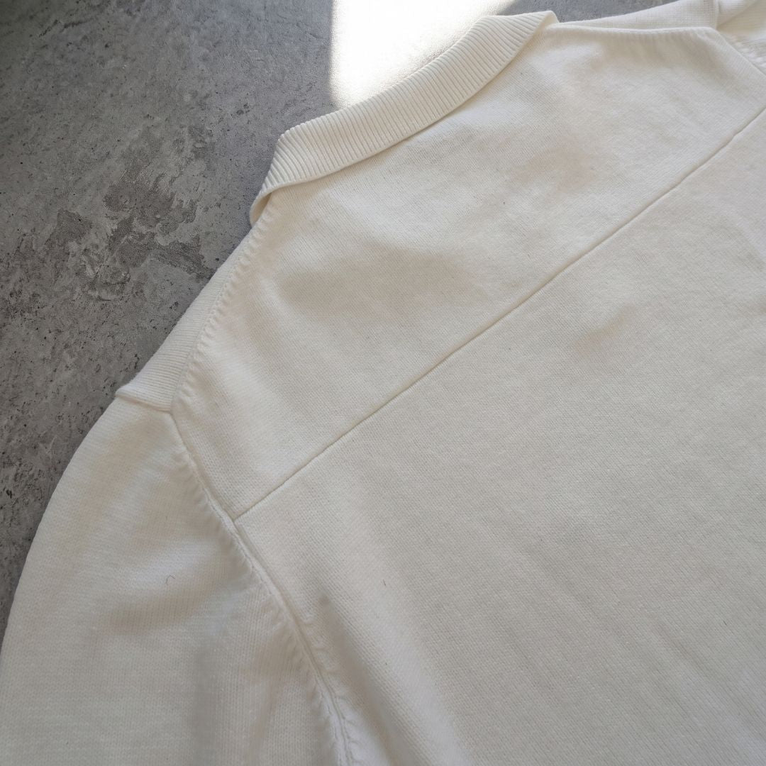 Back collar and raglan seam detail of Euphoric pearl white polo shirt on concrete background