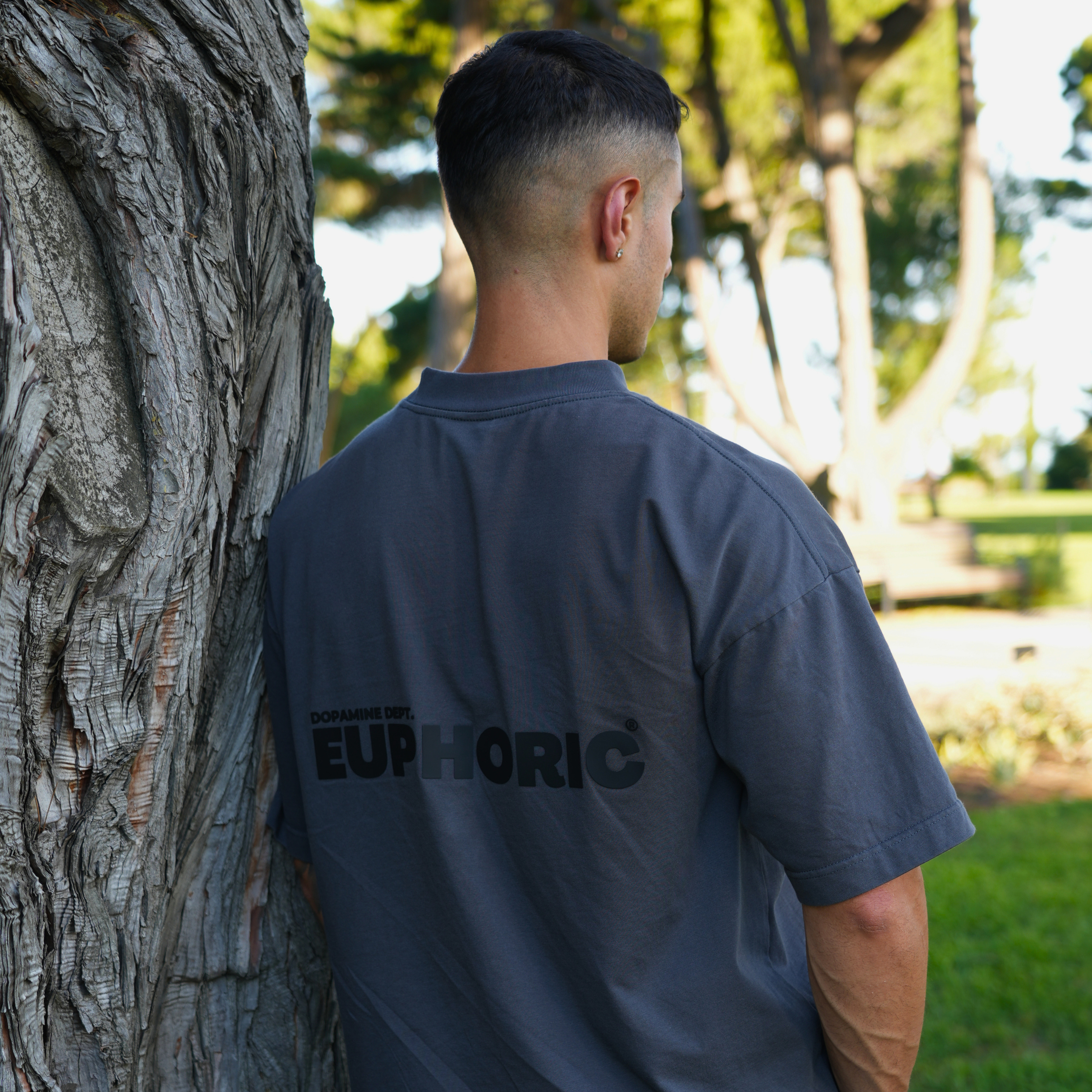 man wearing euphoric poppy seed t-shirt, standing outdoors