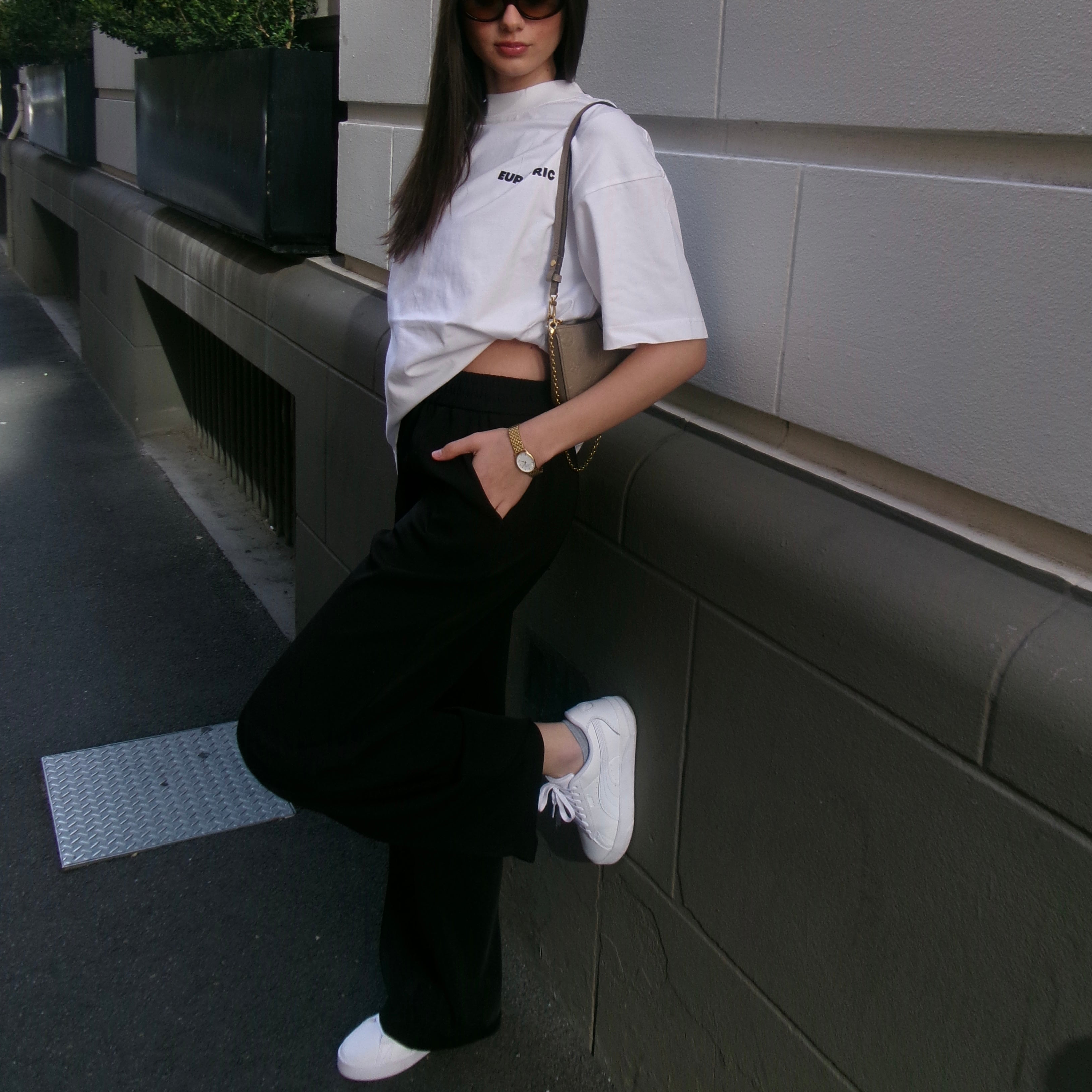 Person wearing a euphoric white oversized shirt and black pants.