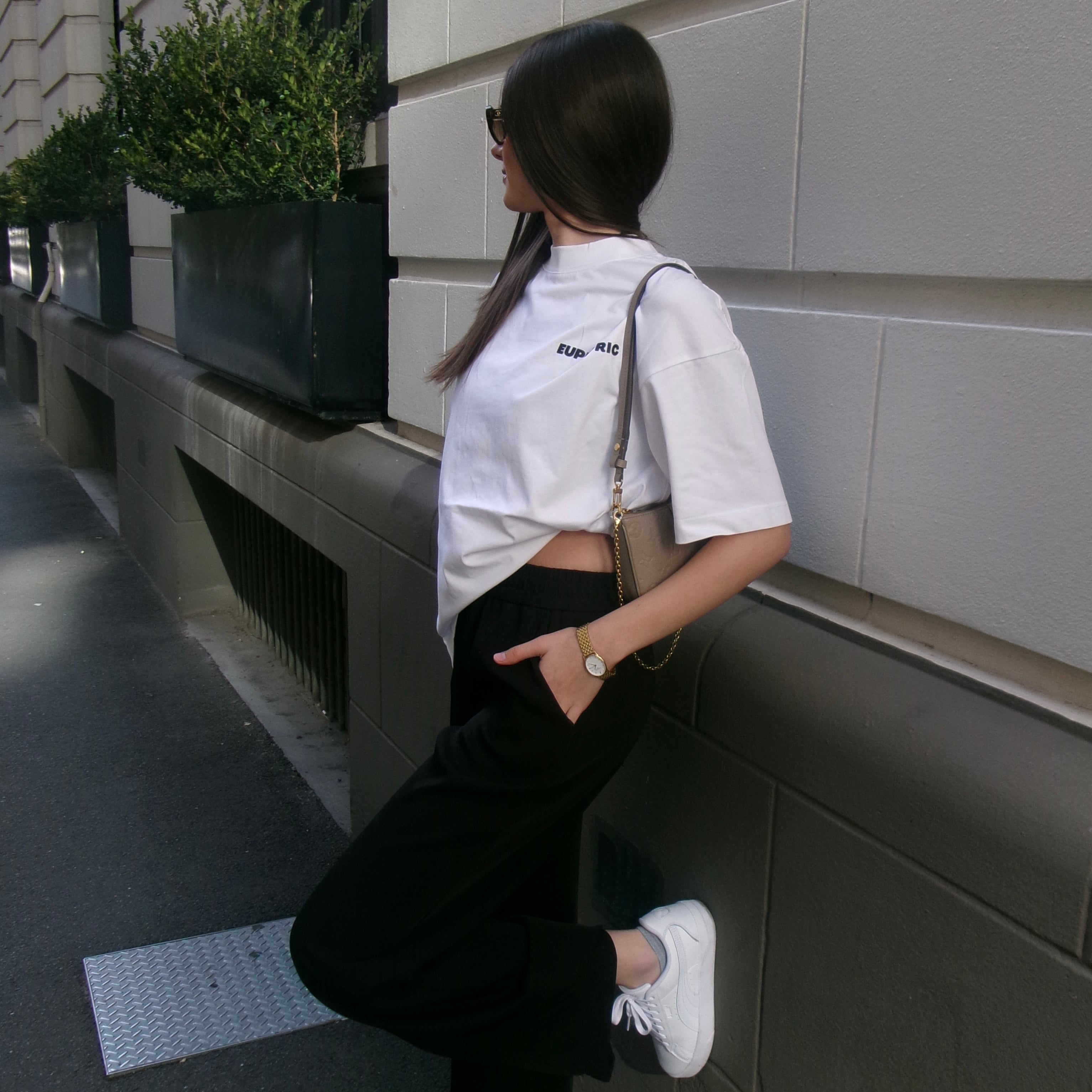 Woman wearing euphoric white t-shirt and black pants